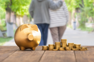 golden piggy bank and coins with an older couple walking off in the background.