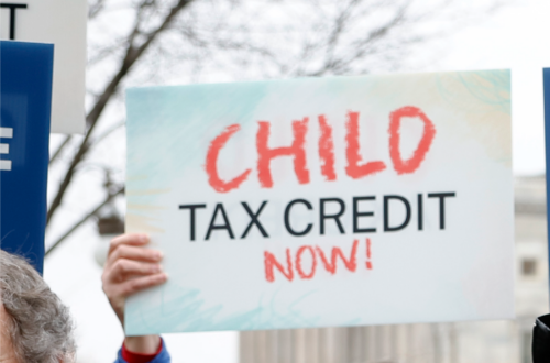 A person holding a sign in front of the capitol that says 