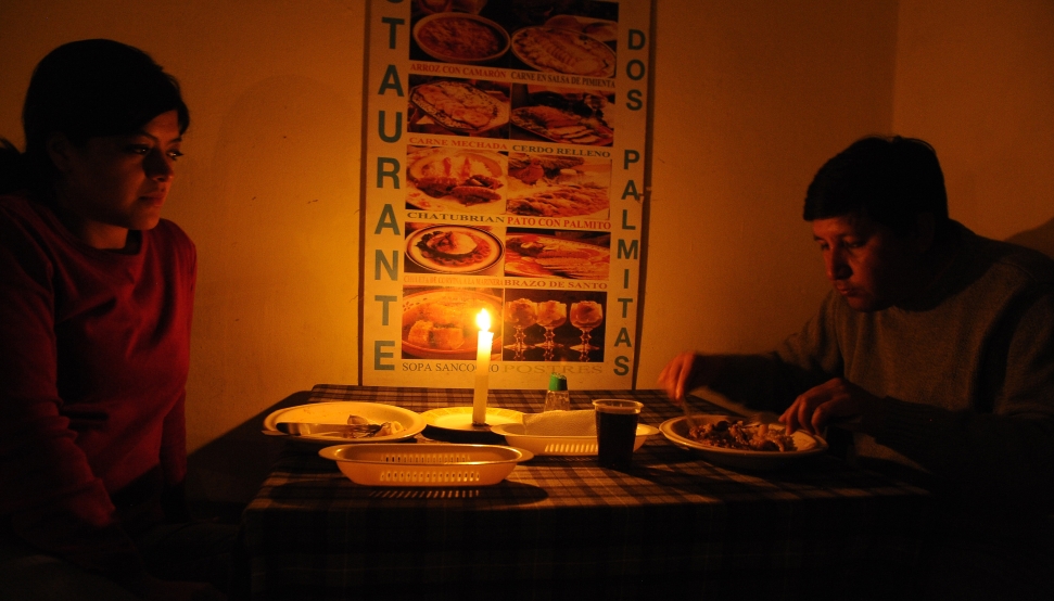 The customers of a small restaurant in Quito eat by candlelight during a blackout. AFP PHOTO / RODRIGO BUENDIA (Photo credit should read RODRIGO BUENDIA/AFP via Getty Images)