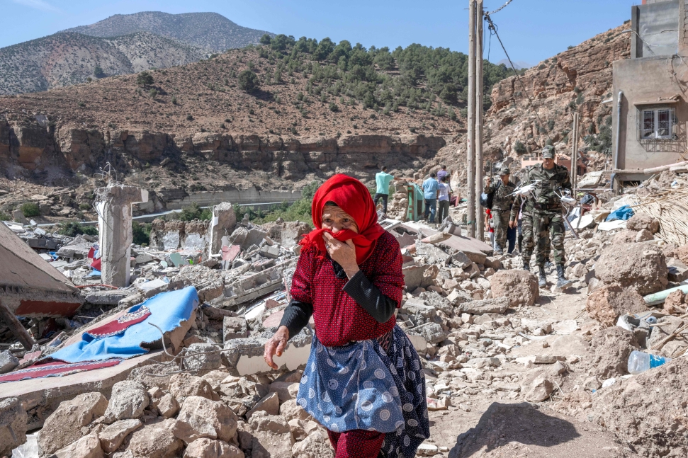 TOPSHOT - A woman walks amid debris in the earthquake-hit village of Imi N'Tala on September 19, 2023. Nearly 3,000 people were killed and thousands more injured when a 6.8-magnitude earthquake tit Morocco's Al-Haouz province on September 8. In its aftermath, many worry that the dire living conditions and poor hygiene spell new threats for the survivors. (Photo by BULENT KILIC / AFP) (Photo by BULENT KILIC/AFP via Getty Images) (Summit of the Future Surcharges Piece)