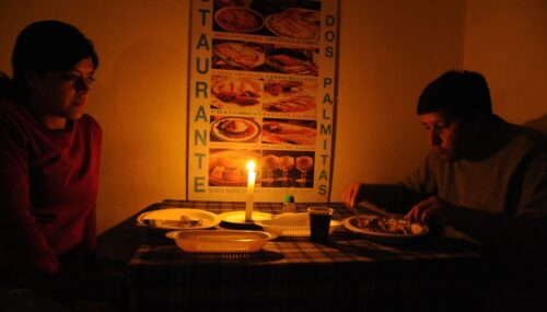 The customers of a small restaurant in Quito eat by candlelight during a blackout. AFP PHOTO / RODRIGO BUENDIA (Photo credit should read RODRIGO BUENDIA/AFP via Getty Images)