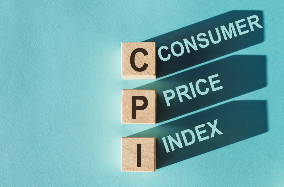 Wooden blocks with the letters "CPI" on a blue background, casting shadows. Next to each block, the words "Consumer," "Price," and "Index" are written in a descending order, giving a sneak peek into the October 2024 CPI preview.