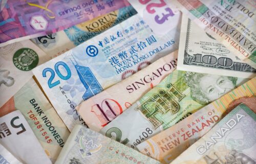 A diverse assortment of currency notes stacked together, showcasing various denominations and designs from around the world.