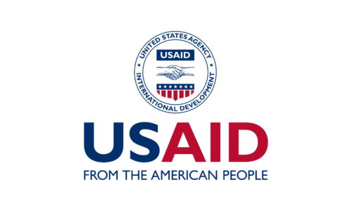 Logo of USAID featuring a circular emblem with a handshake, the words United States Agency International Development, and stylized stars and stripes. Below, the text reads USAID From the American People in blue and red.