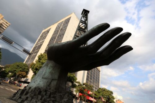 A sculpture of a hand holding an oil drilling rig is pictured outside the state-run oil company Petroleos de Venezuela S.A. (PDVSA) in Caracas on February 26, 2025. US President Donald Trump announced on February 26, 2025, he will reverse the oil 