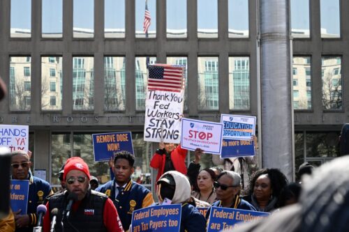 Protesters hold signs in solidarity with the American Federation of Government Employees of District 14 at a rally in support of federal workers at the Office of Personnel Management in Washington, DC, March 4, 2025. Since his inauguration, US President Donald Trump has moved to unilaterally dismantle federal agencies and fired thousands of government workers. (Photo by Alex WROBLEWSKI / AFP) (Photo by ALEX WROBLEWSKI/AFP via Getty Images)