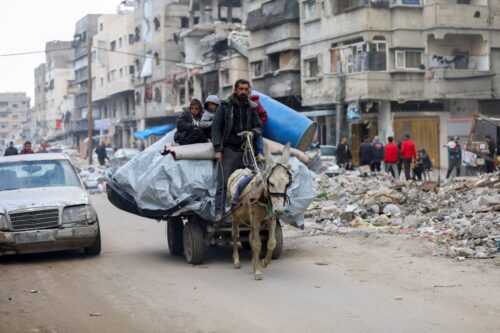 A man moves his family on a donkey-driven cart as dislocated Palestinian refugees flee to find safety in Gaza, Palestinian territories on March 20, 2025. (Photo by Youssef Alzanoun / Middle East Images / Middle East Images via AFP) (Photo by YOUSSEF ALZANOUN/Middle East Images/AFP via Getty Images)