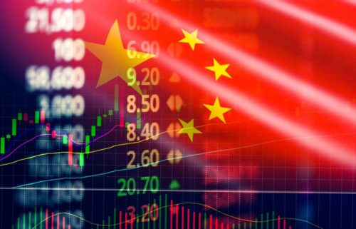 Blurred stock market graph with candlesticks overlaid on a Chinese flag. Numbers and lines suggest financial data, indicating economic activity.