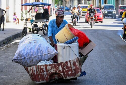 A man carries collected garbage on a street in Havana on July 21, 2025. Poverty levels have increased sharply as the Caribbean country reckons with its worst economic crisis in three decades, marked by shortages of food, medicine and fuel and daily power blackouts. (Photo by YAMIL LAGE/AFP via Getty Images)
