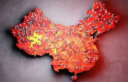 Map of China filled with small, diverse people figures. The red map features yellow stars, resembling the national flag, symbolizing population density.