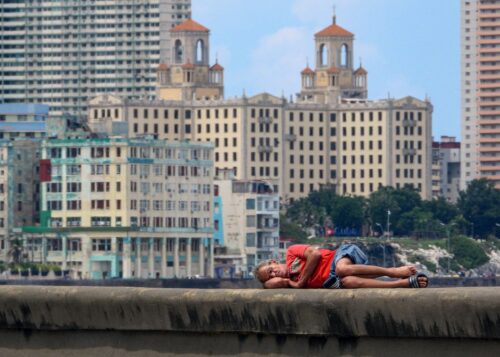 A man sleeps on Havana's Malecon waterfront on October 2, 2025. Poverty levels have risen sharply as Cuba faces its worst economic crisis in three decades, characterized by severe shortages of food, medicine, and fuel, along with daily power outages. (Photo by ADALBERTO ROQUE / AFP) (Photo by ADALBERTO ROQUE/AFP via Getty Images)