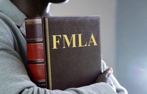 A person holding a large leather-bound book labeled 