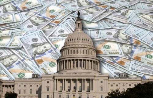 The image shows the U.S. Capitol building overlaid with a large amount of scattered U.S. dollar bills, suggesting themes of politics and finance.