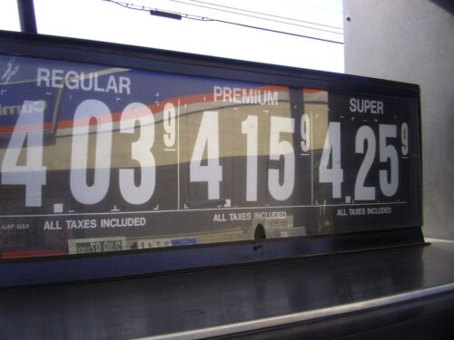 Gas station price sign displaying fuel prices: Regular $4.03, Premium $4.15, and Super $4.25. All taxes are included. The sign features large white numbers on a dark background.