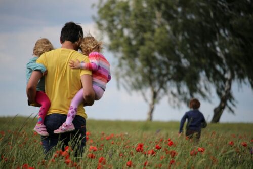 A father stands with his children in a colorful poppy field, surrounded by blooming flowers and a sunny atmosphere. https://unsplash.com/photos/man-carrying-to-girls-on-field-of-red-petaled-flower-O-RKu3Aqnsw?utm_source=unsplash&utm_medium=referral&utm_content=creditShareLink