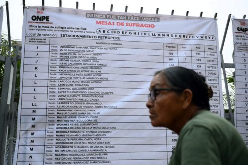 A woman waits to vote outside a polling station in Lima on April 12, 2026, during general elections. Peruvians will elect a new president from a record field of 35 candidates to lead a country plagued by organized crime and chronic political instability. (Photo by Luis ROBAYO / AFP via Getty Images)