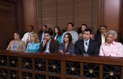 A diverse group of 12 jurors sits attentively in a courtroom. They appear focused and serious, conveying the gravity of a judicial proceeding.